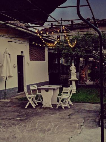 a patio with a table and chairs and an umbrella at Casa Vacanze Terra di Mezzo in Invorio Inferiore