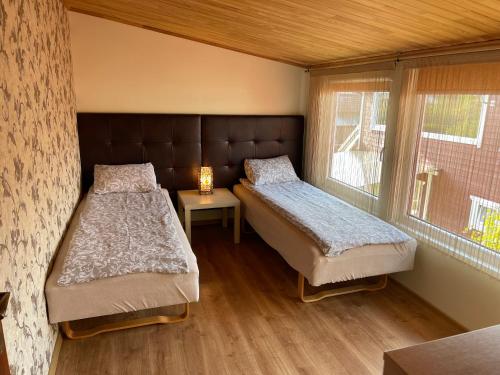 a bedroom with two beds and a window at Ošupio kiemelis in Šventoji