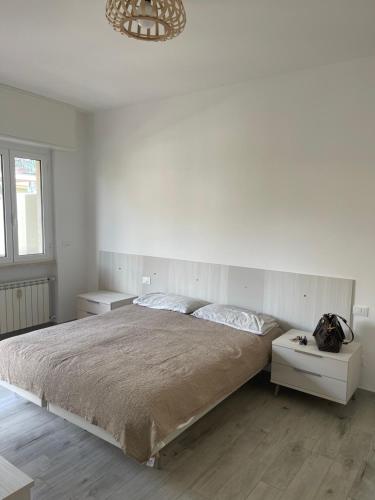 ein weißes Schlafzimmer mit einem großen Bett und einem Kronleuchter in der Unterkunft Casa Viki in Pietra Ligure