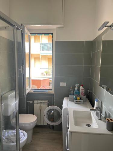 a bathroom with a sink and a toilet and a window at Casa Viki in Pietra Ligure