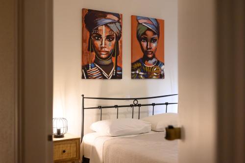 a bedroom with three paintings on the wall at Corfu Dream Holidays Villas in Glyfada