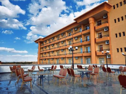 a hotel with tables and chairs in front of a building at نزل الشباب in Ţawd