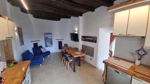 eine Küche und ein Wohnzimmer mit einem Tisch und einem blauen Sofa in der Unterkunft Il Rustico in Maccagno Superiore