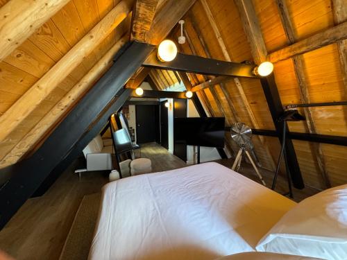 an attic bedroom with a white bed and a piano at Boutique Hotel Johannes in Delft