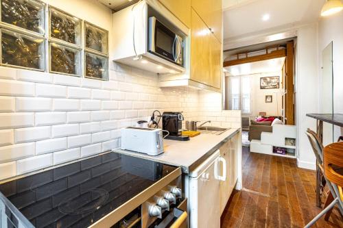 une cuisine avec un évier et un plan de travail dans l'établissement GuestReady - Parisian retreat with a courtyard, à Paris