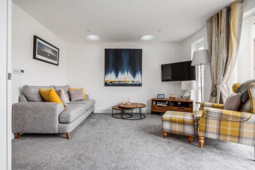 a living room with two couches and a table at Beautiful house in Poole with parking, 2 bed & 2 bathroom in Poole