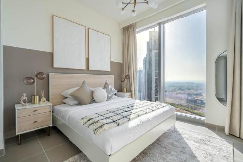 a bedroom with a large bed and a large window at GuestReady - Glamourous home in Downtown Dubai in Dubai