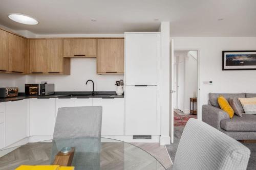 a kitchen and a living room with a glass table at Beautiful house in Poole with parking, 2 bed & 2 bathroom in Poole
