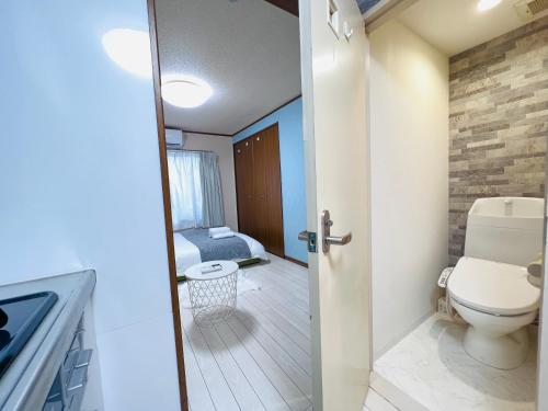 a small bathroom with a toilet and a bedroom at Nishi-shinjuku-ZYZ in Tokyo