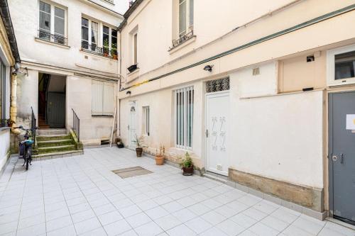 une cour vide d'un immeuble avec un vélo garé entre deux bâtiments dans l'établissement Charmant studio pour 2 - Paris Centre Bastille, à Paris