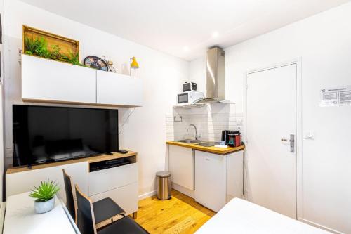 une petite cuisine avec des armoires blanches et un évier dans l'établissement Charmant studio pour 2 - Paris Centre Bastille, à Paris
