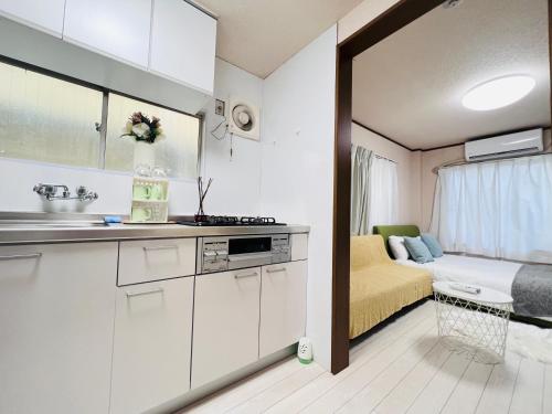 a kitchen with white cabinets and a bed in a room at Nishi-shinjuku-ZYZ SJ0237 in Tokyo
