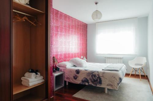 1 dormitorio con 1 cama y una pared de azulejos rosados en Moderno apartamento en el Camino de Fisterra, en Negreira