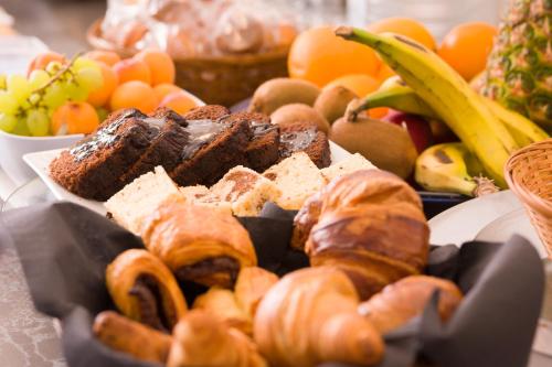 a tray of pastries and bread and other fruits and vegetables at Hotel Marfil in San Antonio