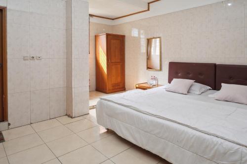 een slaapkamer met een groot bed en een douche bij Wisma Rumka in Jakarta