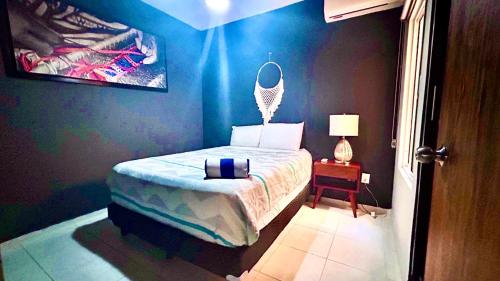 a bedroom with a bed and a table with a lamp at Playa Del Carmen Apartment in Playa del Carmen