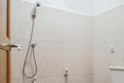 a shower with a shower head in a bathroom at Wisma Rumka in Jakarta