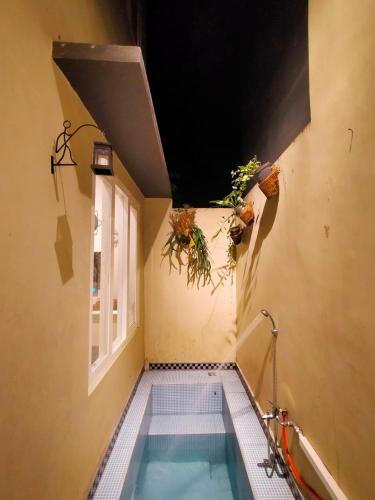 a swimming pool in a room with a window at Villa Gamping Favika Batu in Batu