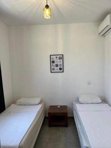 a room with two beds and a table in it at Cocobana Resort two-bedroom apartment ground floor in Willemstad