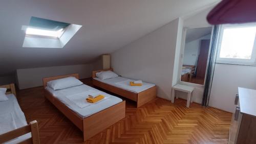 a small room with two beds and a window at Apartment SKY in Novalja