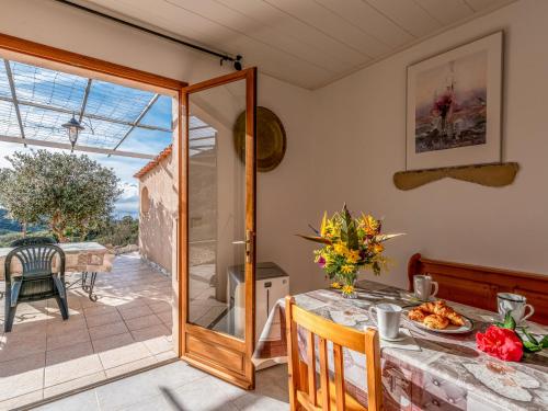 une salle à manger avec une table et une porte en verre dans l'établissement Holiday Home Campestra by Interhome, à Coti-Chiavari