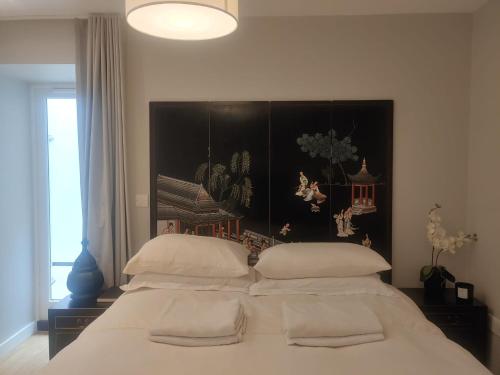a bedroom with a large bed with white pillows at Luxurious duplex design-flat Kensington in London