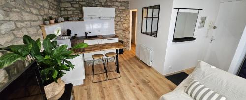 une cuisine et un salon avec un canapé et une table dans l'établissement Le charme de la pierre, à Lorient