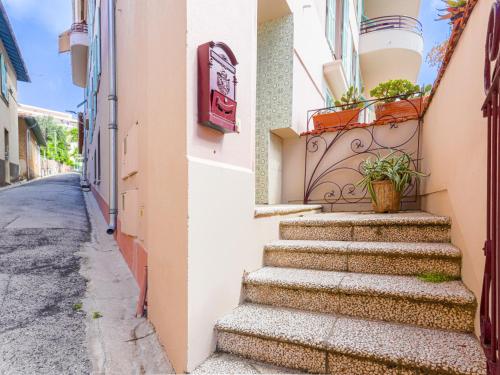 un escalier menant à un bâtiment avec une plante dans l'établissement Apartment Le Palais Foch by Interhome, à Villefranche-sur-Mer
