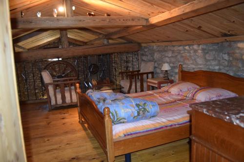 une chambre avec un lit dans une cabane en rondins dans l'établissement Le Mas Hauregard, à Les Mages