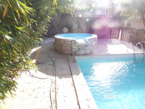 - une piscine dans une cour à côté dans l'établissement Le Mas Hauregard, à Les Mages