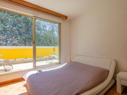 une chambre avec un lit et une grande fenêtre dans l'établissement Holiday Home Résidence La Corniche d'or by Interhome, à Saint-Raphaël