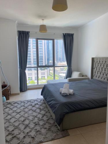 a bedroom with a bed and a large window at The residences 1 - Luxury 1BR apt in Downtown Dubai - 2 mins walk to Burj Khalifa & Dubai Mall in Dubai