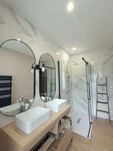 a bathroom with two sinks and a large mirror at # Le Beffroi# Maison# Murol in Murol