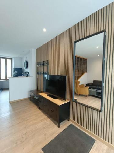 a living room with a television and a mirror at # Le Beffroi# Maison# Murol in Murol