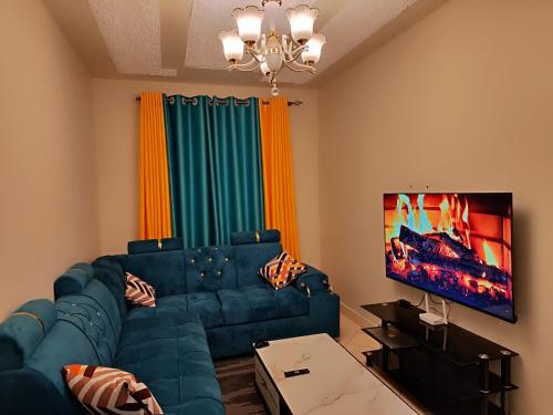 KikuyuRomantic 1Bedroom Gateway in Kinoo的客厅配有蓝色的沙发和平面电视。