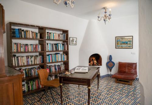 a living room with a desk and a fireplace at Lalla Ghayta in Chefchaouene