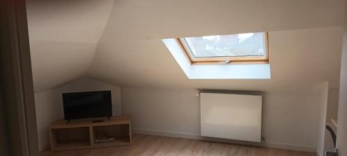 un salon avec une télévision et une fenêtre dans l'établissement La Phalecque, à Lille