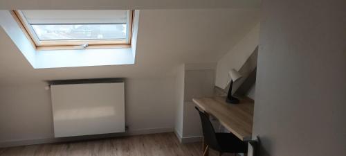 Cette chambre mansardée comprend un bureau et une fenêtre. dans l'établissement La Phalecque, à Lille