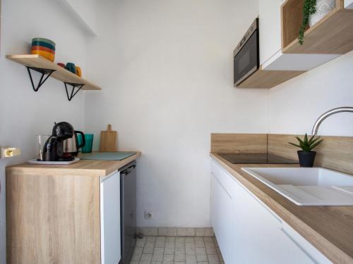 une petite cuisine avec un évier et un comptoir dans l'établissement Studio le ponant by Interhome, à Saint-Laurent-du-Var