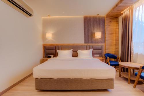 a bedroom with a bed and a table and chairs at Hotel Vasundhara Palace in Rishīkesh