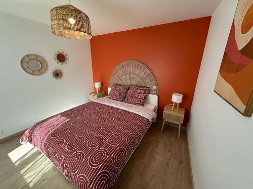 a bedroom with a large bed with red walls at La P'tite maison de Trého in Tréhorenteuc