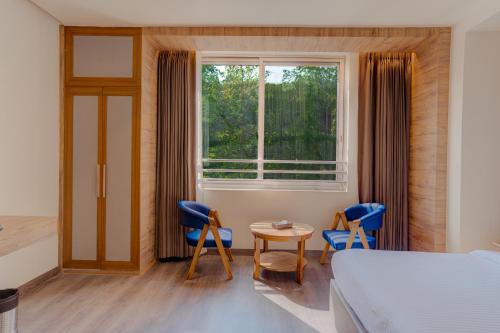 a bedroom with a bed and a table and chairs at Hotel Vasundhara Palace in Rishīkesh