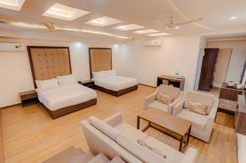 a living room with two beds and a couch and chairs at Hotel Vasundhara Palace in Rishīkesh