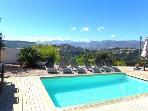 - une piscine avec des chaises et une vue sur les montagnes dans l'établissement Villa Les Oliviers by Interhome, à Nice