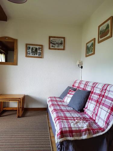 - un salon avec un canapé et une couverture tressée dans l'établissement Perle des Alpes, à Saint-Gervais-les-Bains