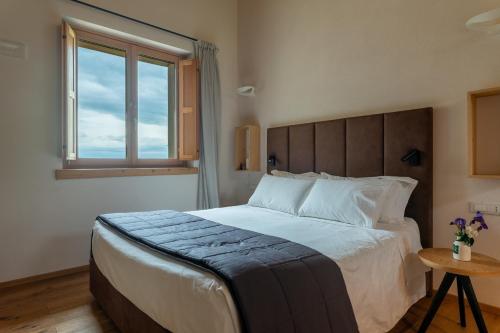 a bedroom with a large bed and a window at Aura Relais in Urbino