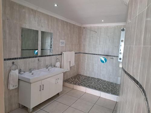 een badkamer met een wastafel en een douche bij St Helena Bay Hotel in St Helena Bay