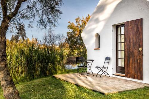 Casa blanca pequeña con terraza de madera en Les Bains Gardians, en Saintes-Maries-de-la-Mer