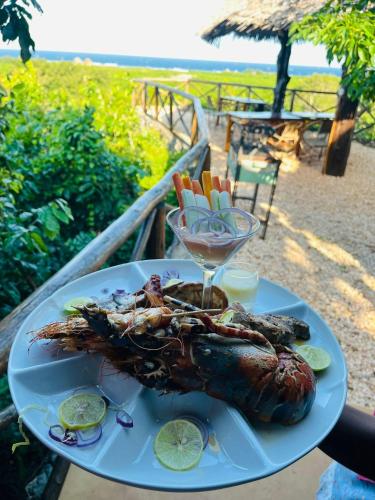 a plate of food with a lobster on a table at MONKEY MOUNTAIN LODGE in Mtende