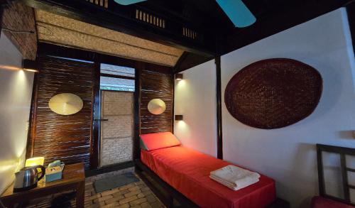 Habitación con cama roja y ventana en Beach Bar Hue Hostel, en Hue